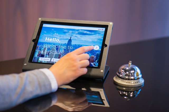 guest checking into a hotel using a tablet at the front desk