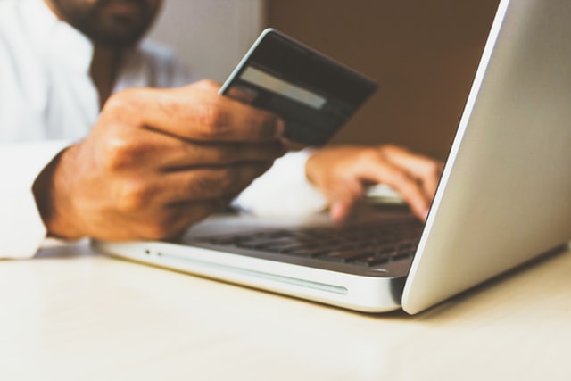 man making a purchase with a credit card on his laptop